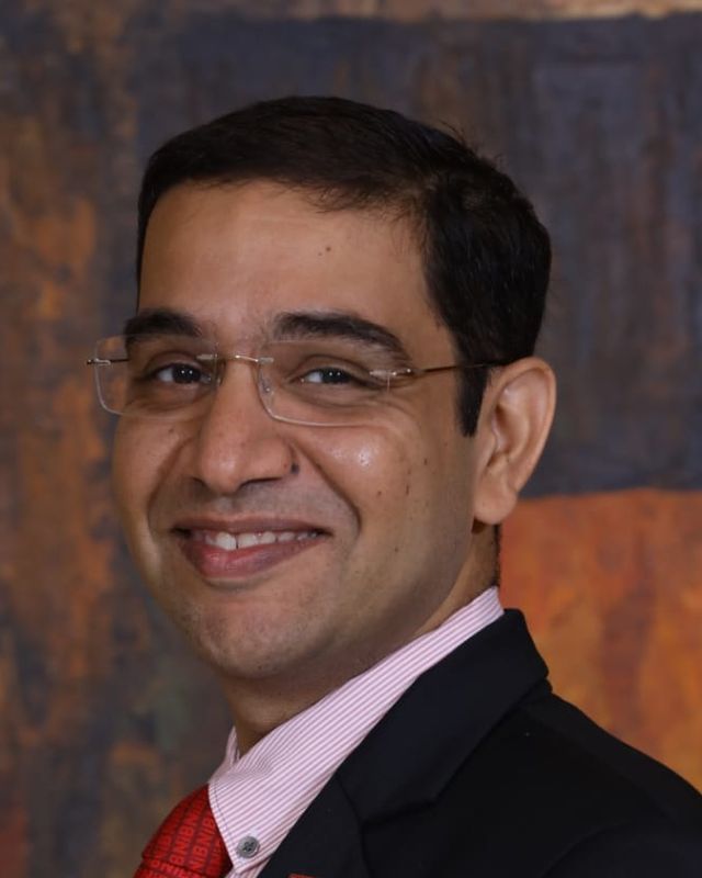 Pankaj Anand, smiling, in a dark suit